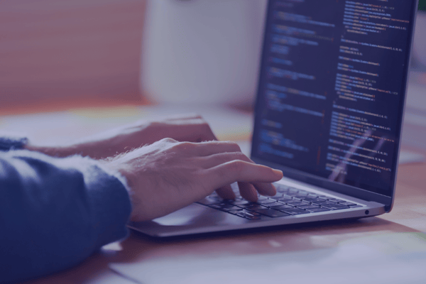 Close-up of hands coding on a laptop